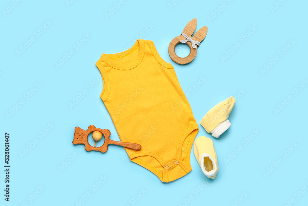 彩色背景带玩具和短靴的婴儿服装
