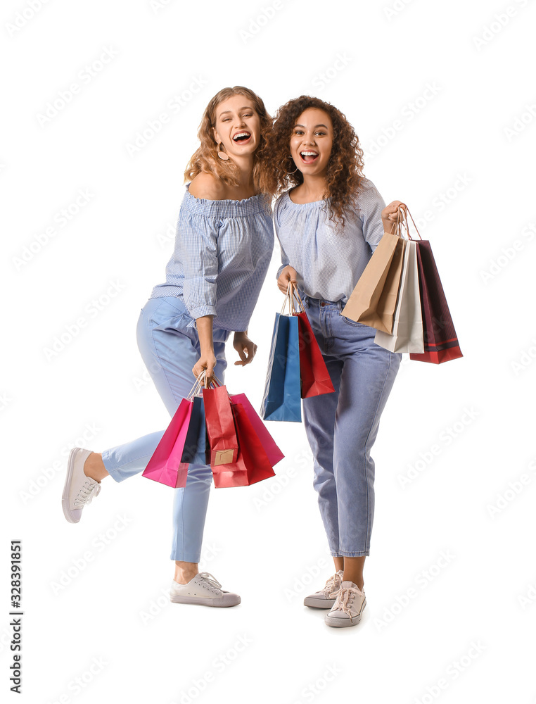 Beautiful young women with shopping bags on white background