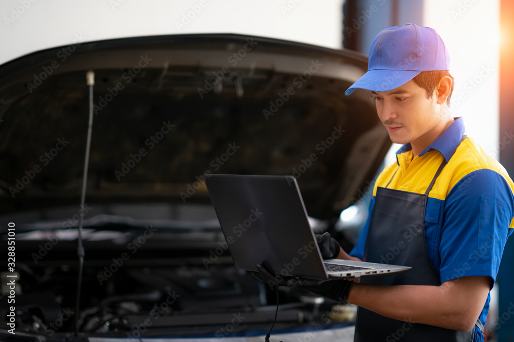 汽车维修技术人员使用笔记本电脑测量发动机数值进行分析