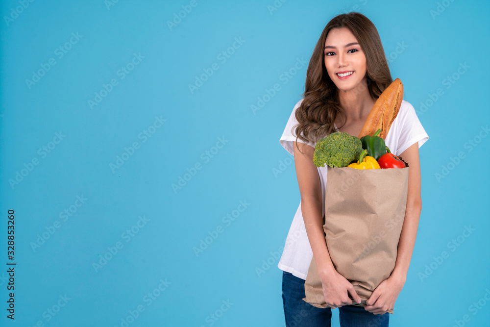 亚洲美女拿着装满蔬菜和杂货的纸质购物袋