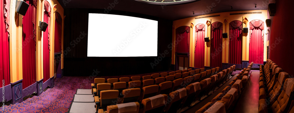 Cinema theater screen in front of seat rows in movie theater showing white screen projected from cin