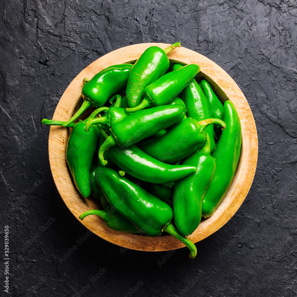 木板里的绿色墨西哥胡椒。美食摄影