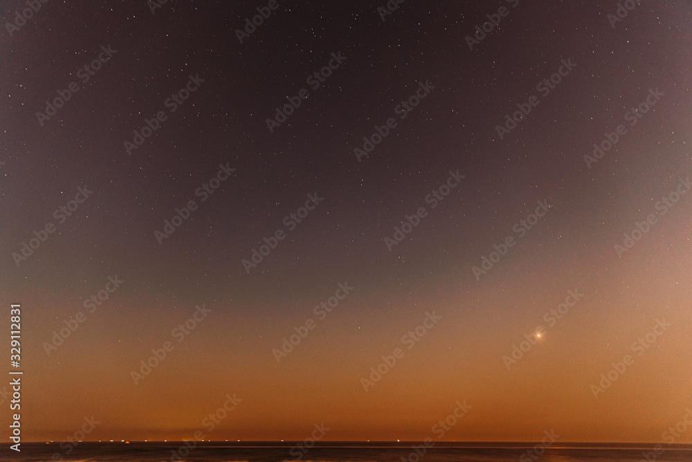 真正的彩色夜晚日落天空之星。海景海洋海滩上方的自然星空。背景