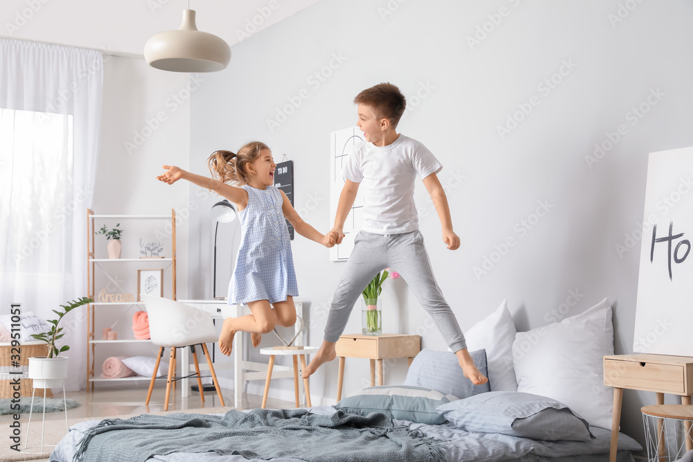 Happy children having fun in bedroom at home