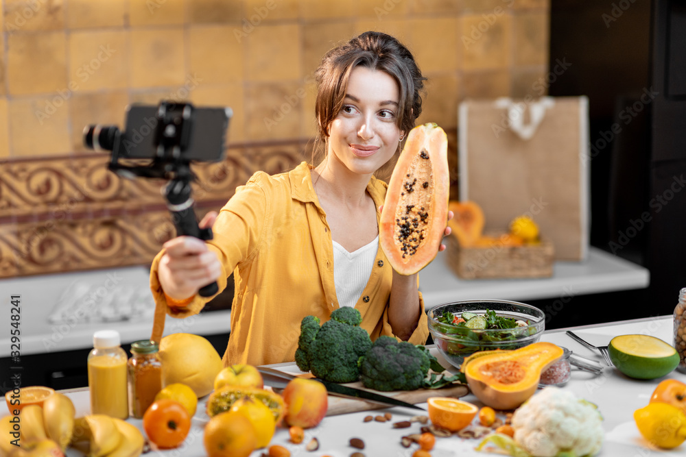 年轻开朗的女性在手机上写关于健康食品和烹饪的视频。健康的概念