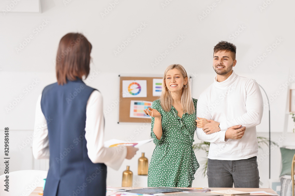 Female interior designer working with couple in office