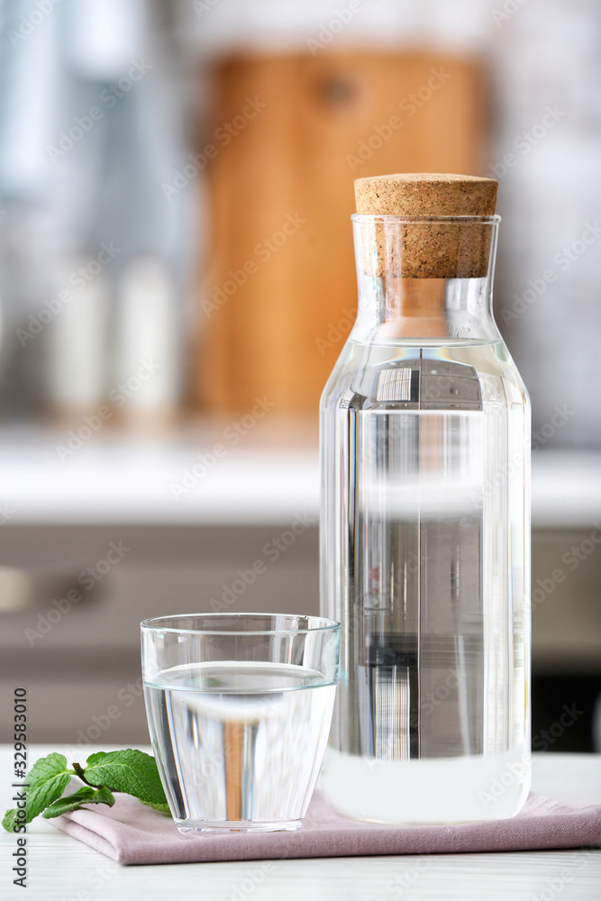 厨房餐桌上的玻璃杯和一瓶新鲜冷水
