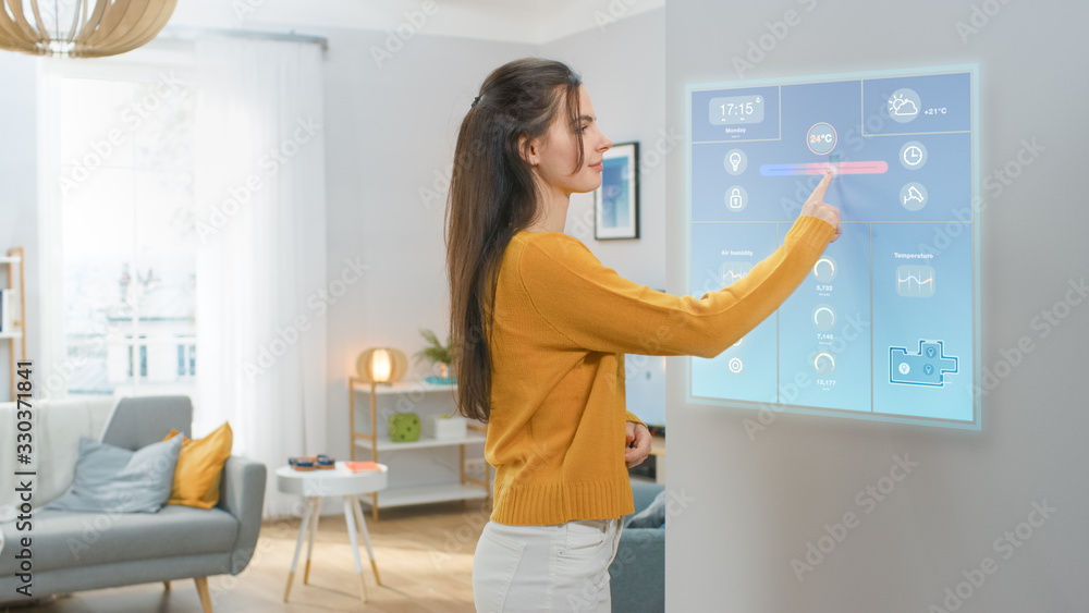Beautiful Young Girl Walks Over to a Refrigerator. She is Changing Temperature on a Smart Fridge Scr