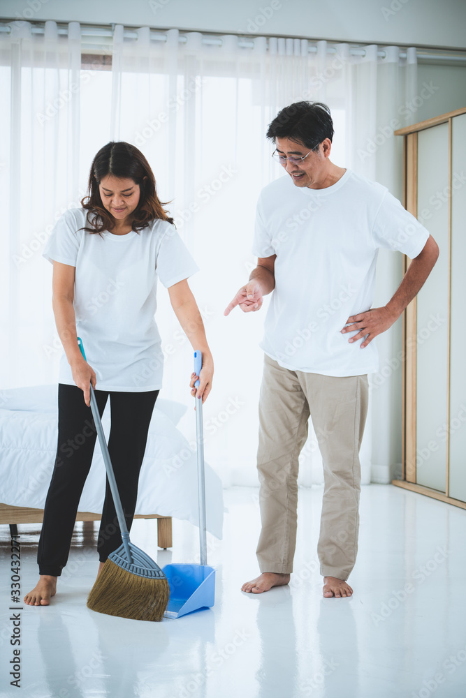 亚洲老年夫妇打扫卧室地板。退休和健康的老年人概念。