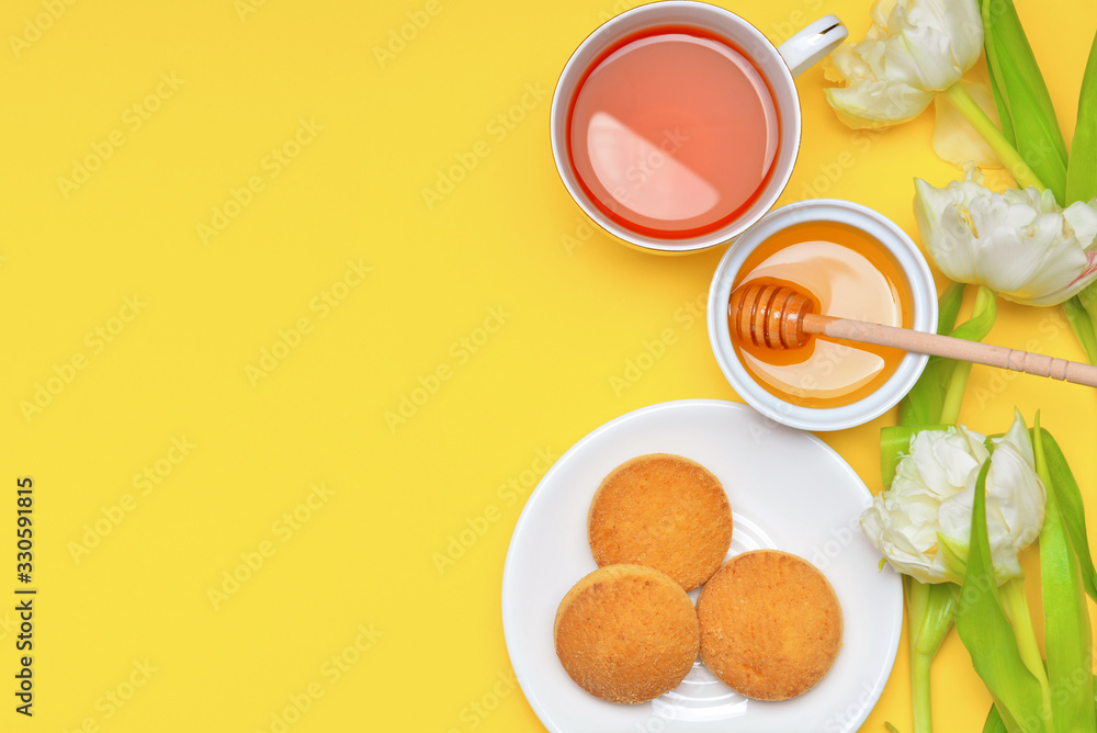 Tasty honey with cookies and cup of tea on color background