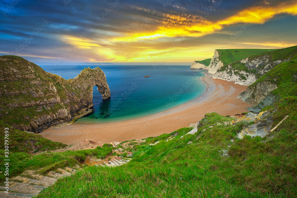 日落时分，英国多塞特侏罗纪海岸海滩上的Durdle Door