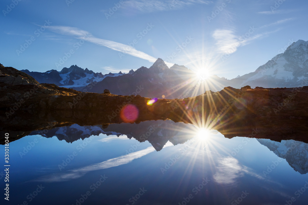 太阳在法国阿尔卑斯山的切瑟里湖（Lac De Cheserys）升起。山麓的比安科山脉