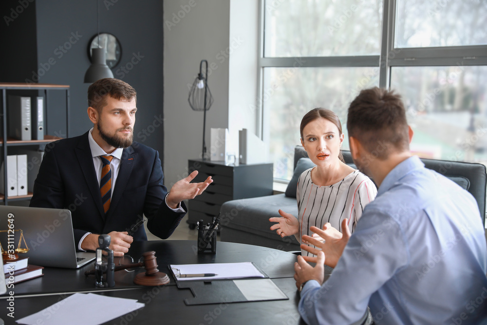 Male lawyer working with stressed couple in office