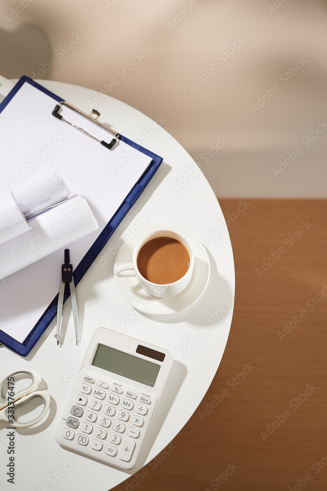 白色桌子上的咖啡笔记本空页、计算器、咖啡杯剪刀俯视图