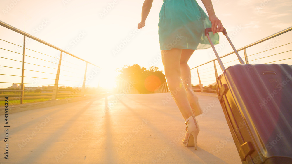 LENS FLARE: Woman in a green sundress tries to catch her flight at sunset.