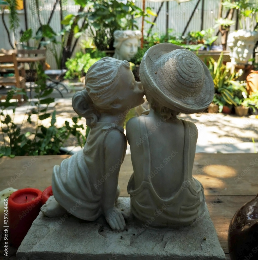 浪漫的大理石娃娃，芳香的小女孩和男孩，花园背景