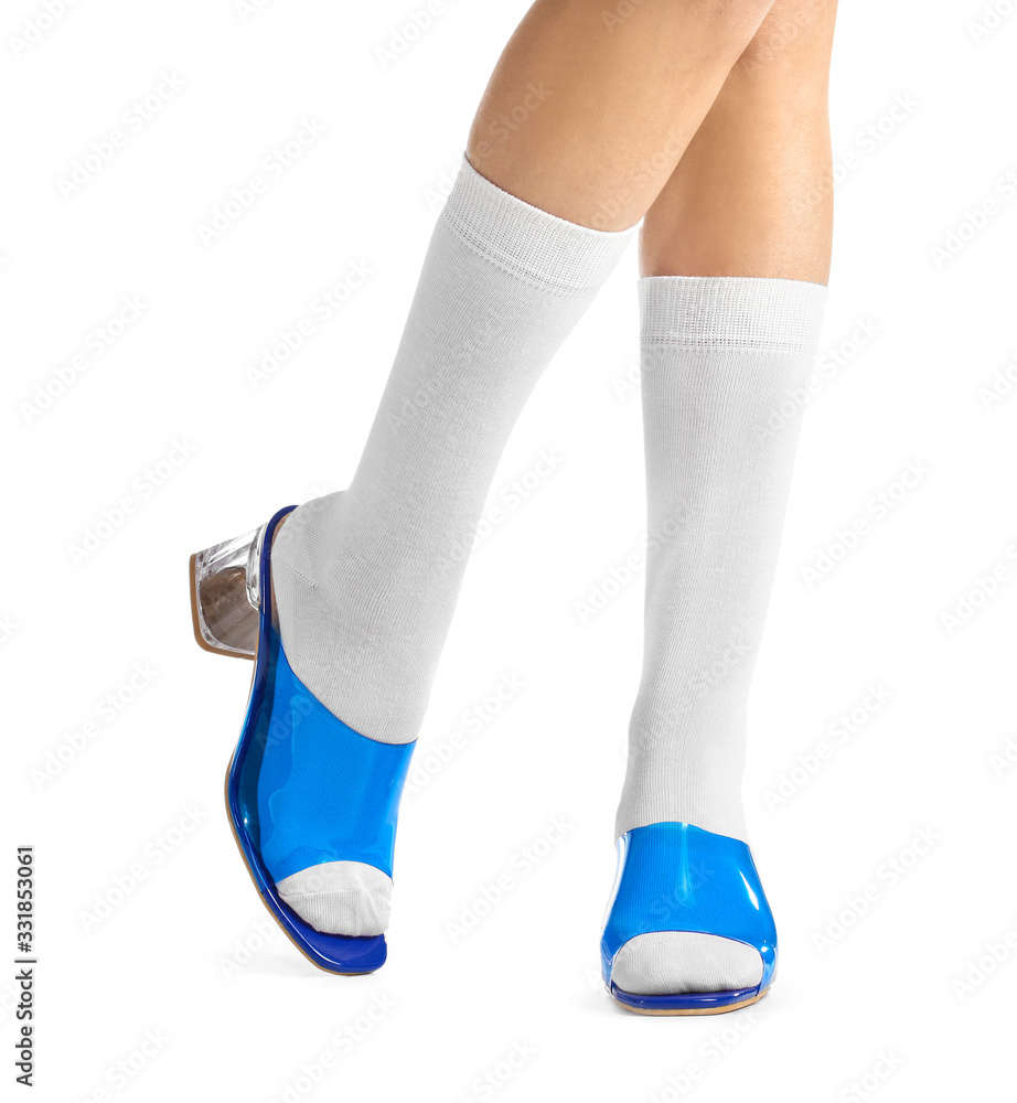 白色背景下穿着袜子和鞋子的年轻女子的腿