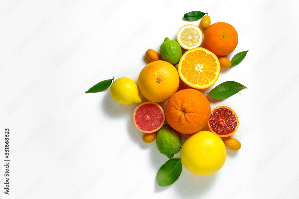 Close up image of juicy organic whole and halved assorted citrus fruits, green leaves & visible core