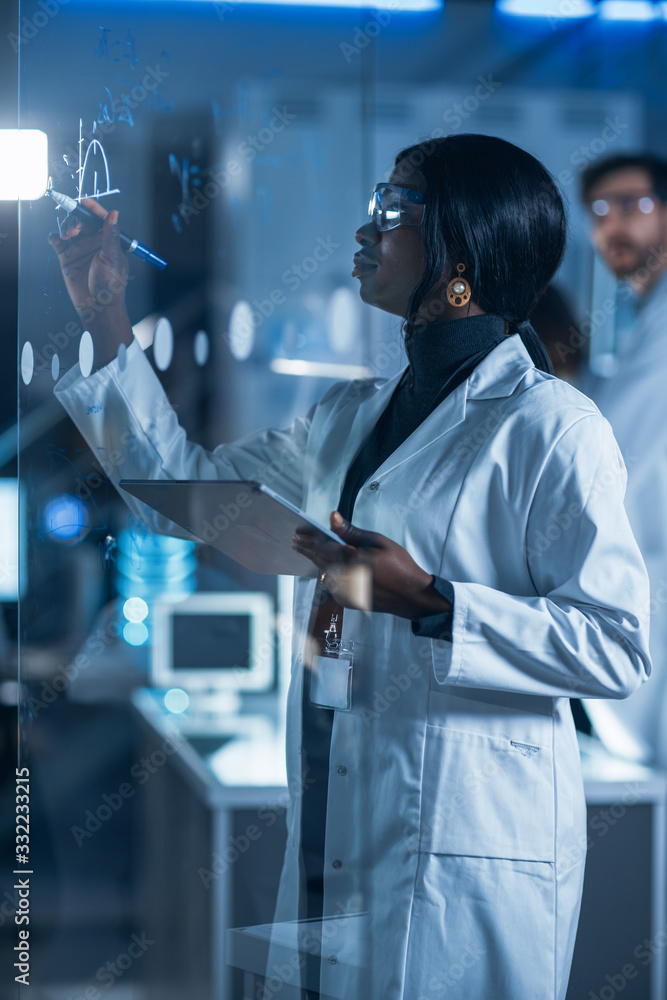 在研究实验室里，穿着白大褂的聪明美丽的非裔美国女科学家