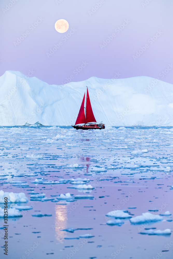 日落后，在满月升起前，一艘挂着红帆的帆船在冰山间巡航。Dis