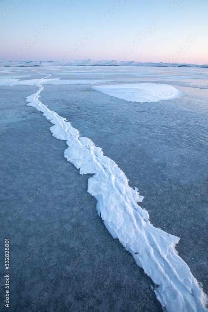 日出时贝加尔湖结冰的冬季景观。俄罗斯西伯利亚贝加尔湖。