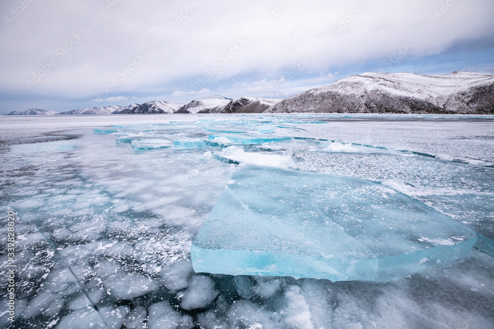 阴天贝加尔湖上蓝色多层冰的超现实冰冻冬季景观。贝卡湖