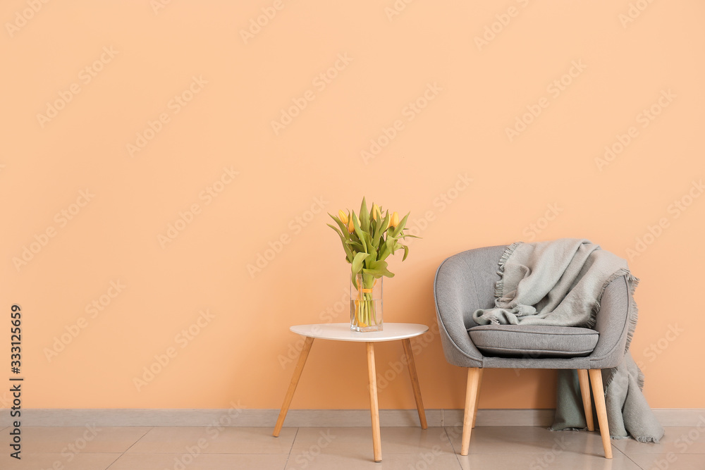 现代房间内部，配有舒适的扶手椅和靠近彩色墙的春花桌子