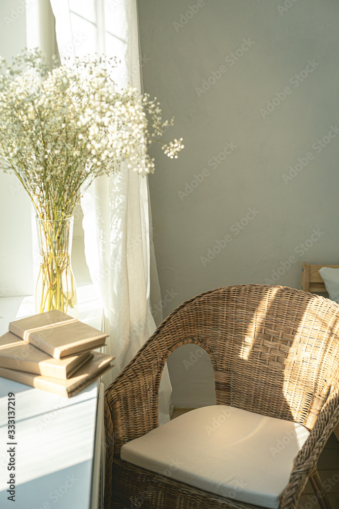 窗户边舒适的阅读角落，藤制柳条椅，精致的白色吉普赛花，打开了