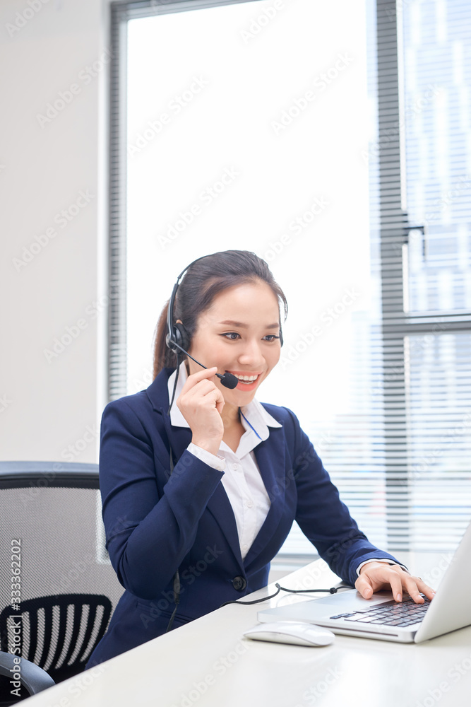 工作场所快乐微笑的女性客户支持电话接线员的画像。亚洲人