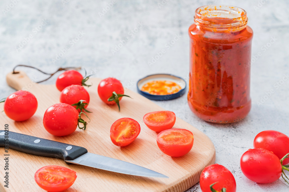 切菜板上的樱桃番茄和一勺番茄酱