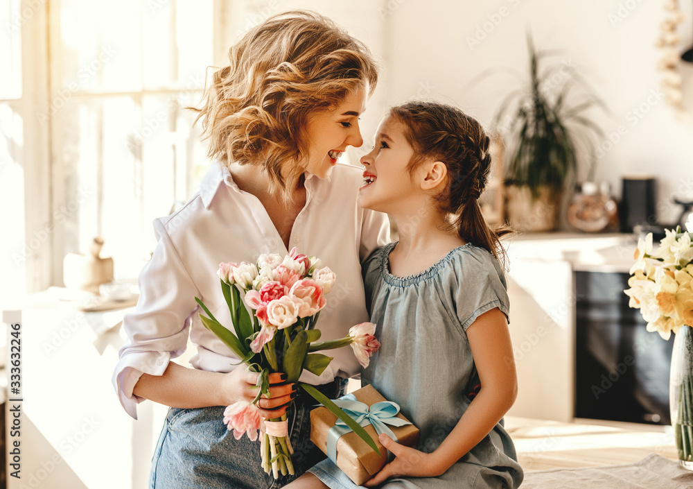 happy mothers day! child daughter gives flowers for  mother on holiday