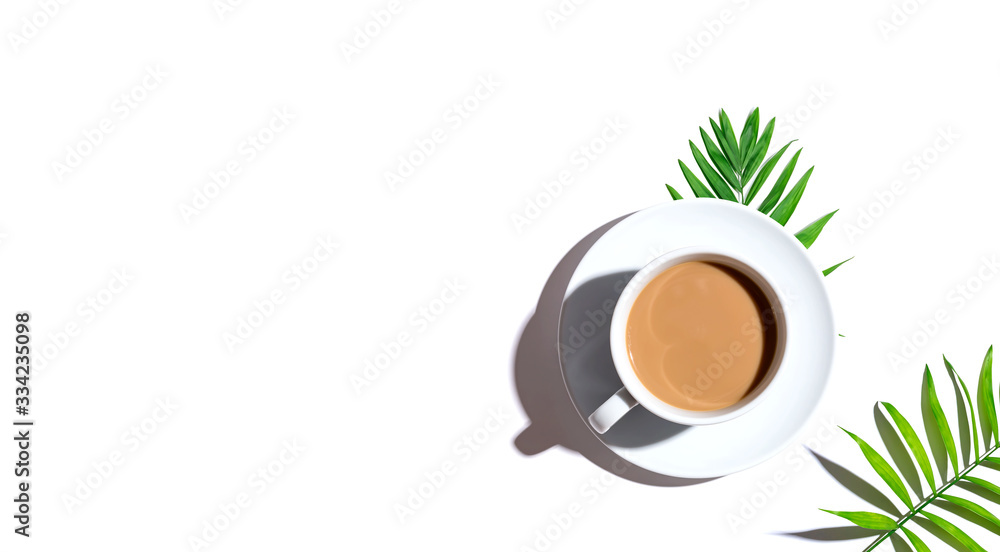 A cup of coffee with tropical leaves - flat lay