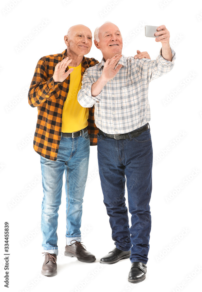 Portrait of elderly men taking selfie on white background