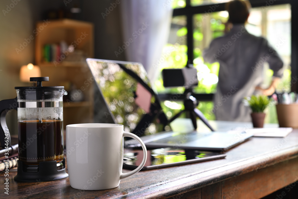 一个在家工作的人在办公桌上放着一台咖啡机和一个杯子