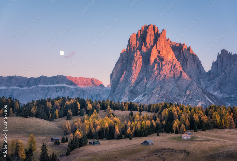 美丽的山脉，日落时有明亮的山峰。秋天的风景，小木屋，山