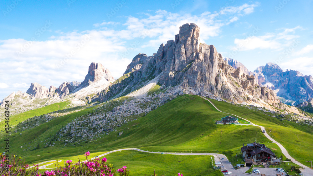 Dolomite rocks and green grass in Italy on a sunny summer day