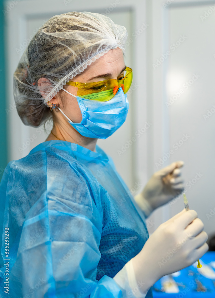 Portrait of nurse working in operating theatre. Waist up portrait of female medical worker in protec