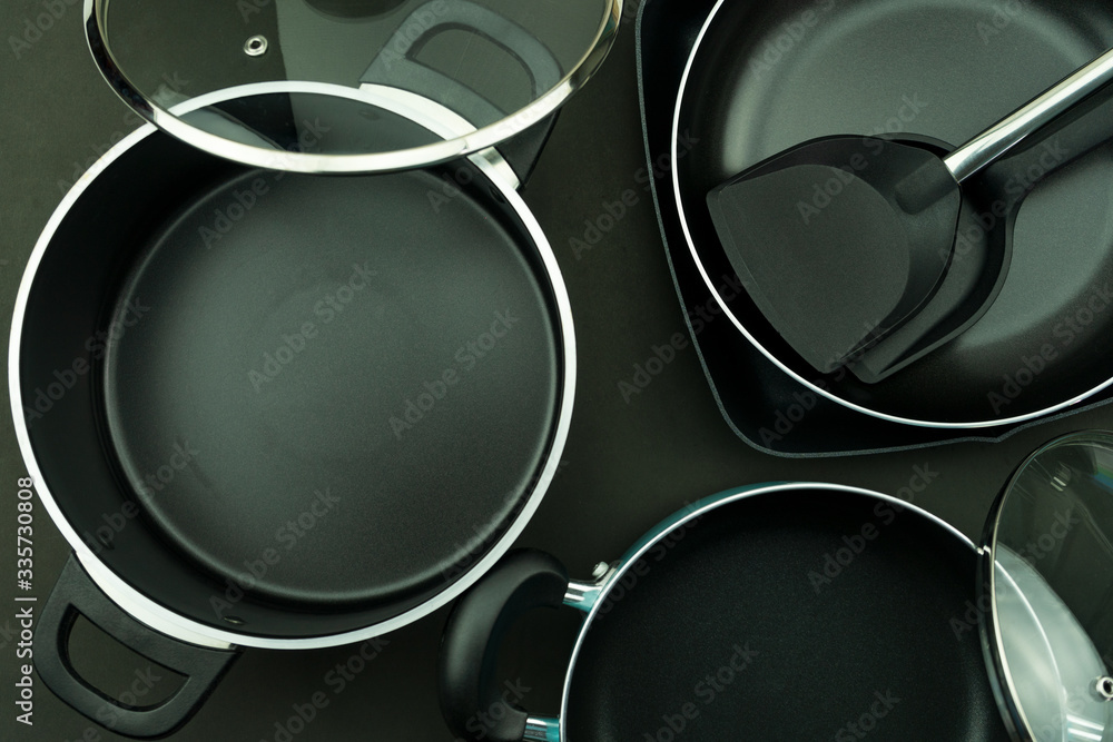 黑色背景的煎锅和锅的俯视图。