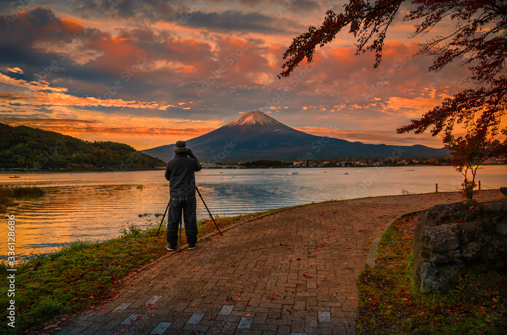 旅行者男子在富士山和河湖日落时拍摄富士山和湖的后视图