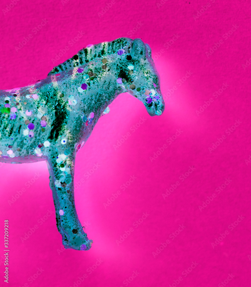 Aerial view of horse figurine toy with negative effects in a colorful background