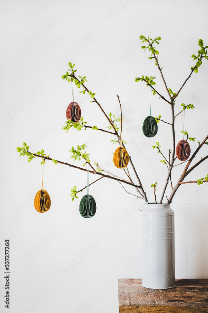 复活节假期家居装饰。花瓶里的树枝和新鲜的春天树叶装饰着节日