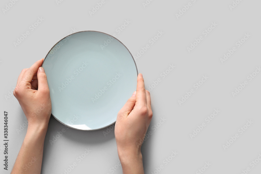 Woman at table with clean plate, top view