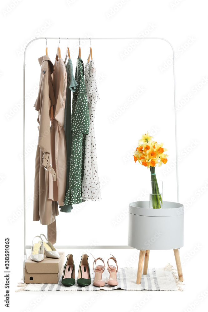 Rack with clothes and shoes on white background