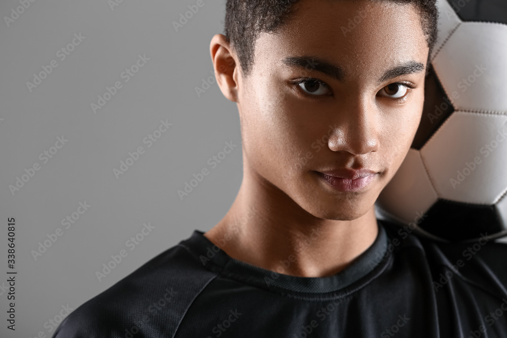 灰色背景下的年轻非裔美国足球运动员