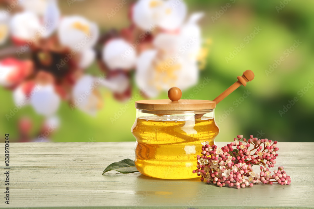 Jar of sweet honey on table outdoors