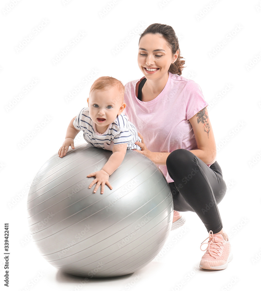 年轻的运动型妈妈和她的宝宝在白色背景下用健身球做运动