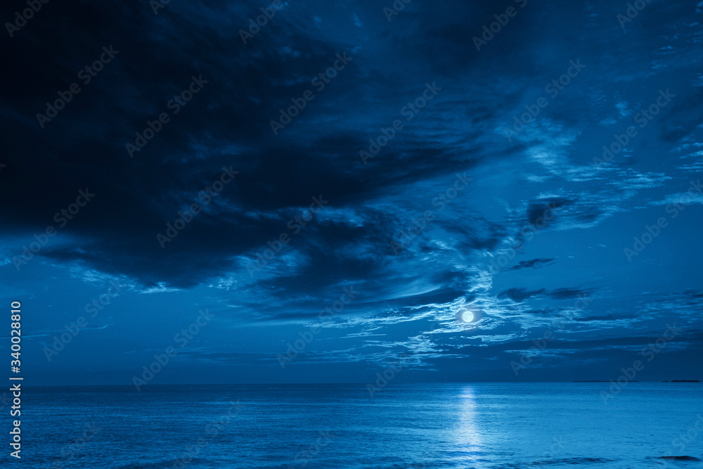 这张照片描绘了深蓝色的月光海洋和夜晚的天空，这将是一次很棒的旅行。