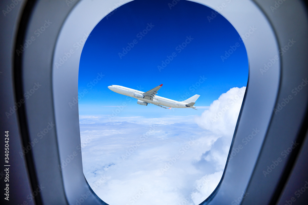 从飞机窗口看飞机在云层上方飞行，旅行概念。