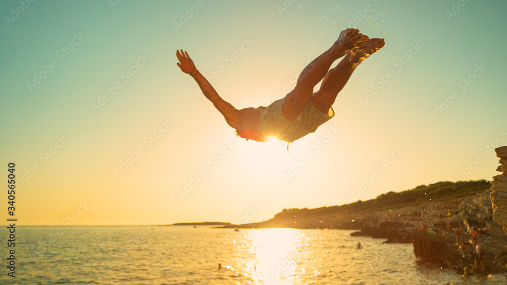 特写：日落时，美丽的金色阳光照射在健康人的悬崖跳水上。