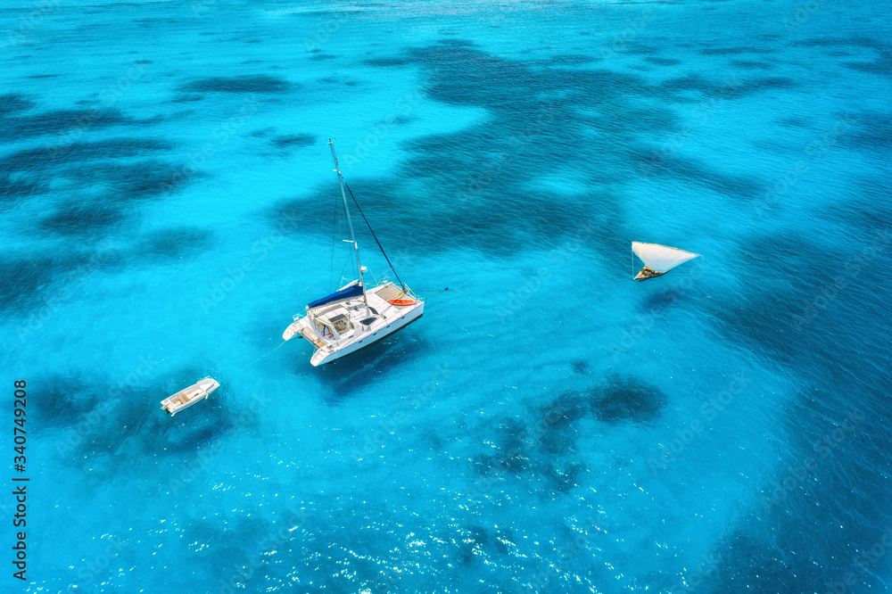 Aerial view of the yacht and sailboat in clear blue sea at sunset in summer. Top view of fishing boa